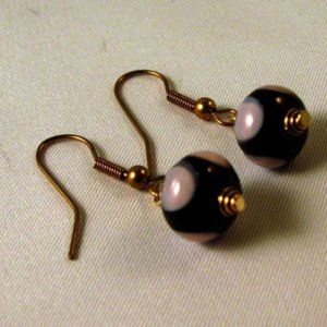 Pink polka dot earrings on a black
